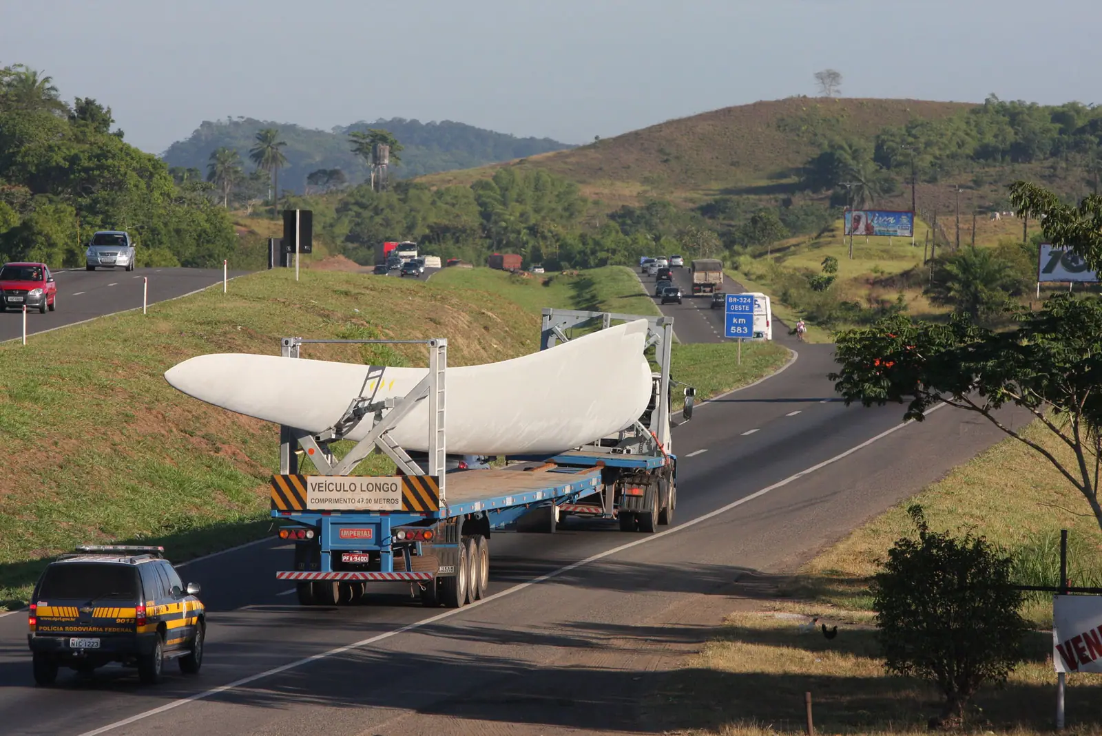 Trecho duplicado da BR-324 com tráfego de caminhões e ocupação urbana na margem